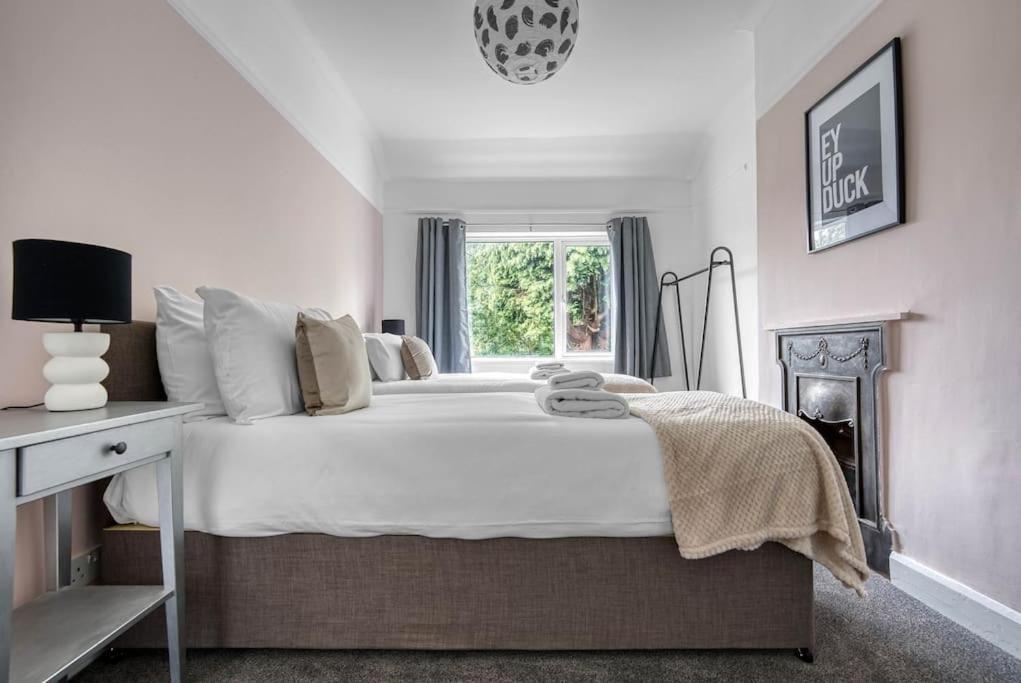 - une chambre avec un grand lit blanc et une fenêtre dans l'établissement Stylish Home - Fast Wi-Fi-FREE Parking, à Nottingham