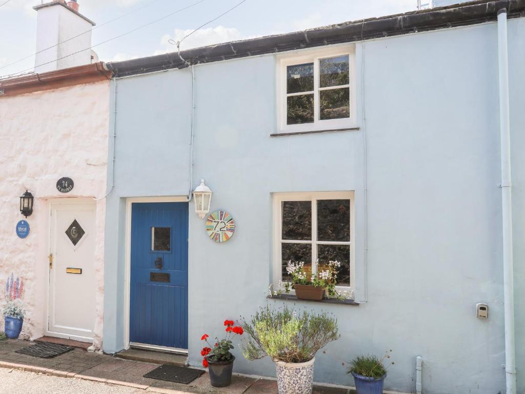 a white house with a blue door and windows at Blue Cottage in Beaumaris