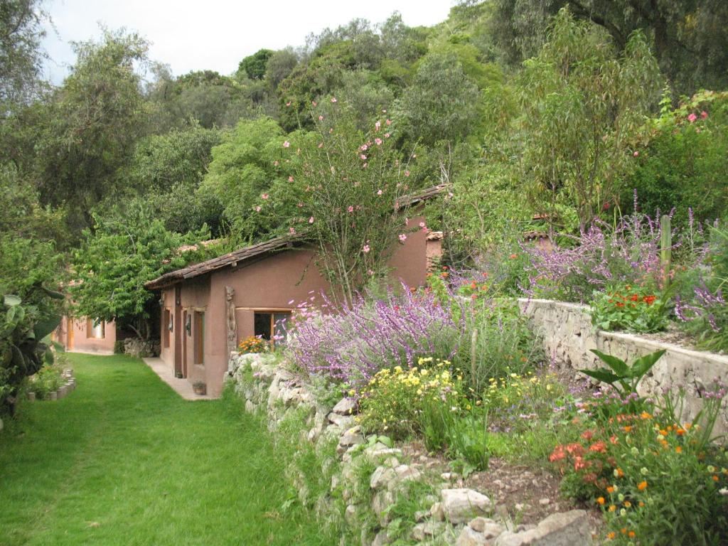 un jardín con flores y una pared de piedra en Andean Spirit Lodge, en Limatambo