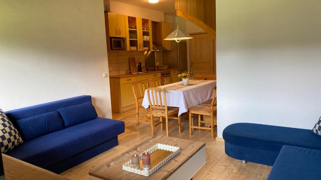 a living room with a blue couch and a table at Apartment Steinwänd Top 8 in Grünau im Almtal