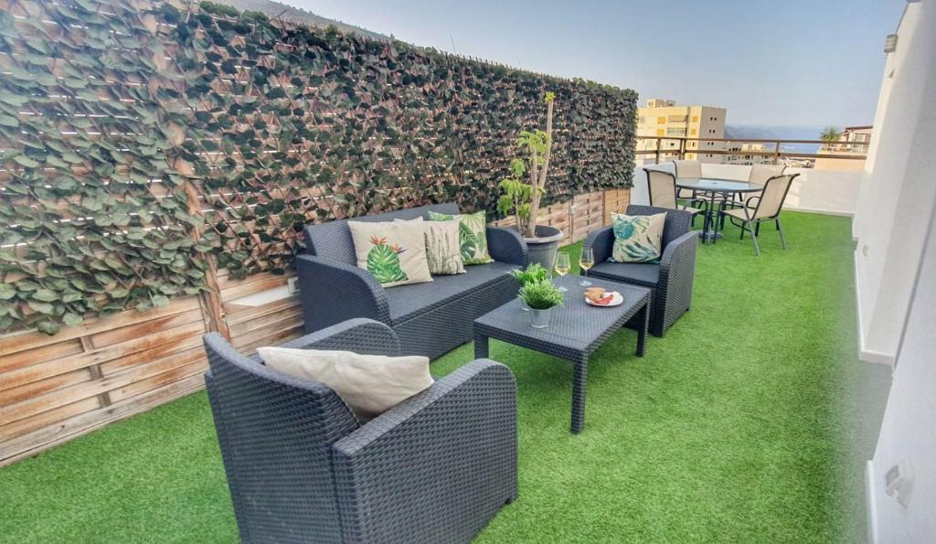 un patio con sillas, mesas y una pared de ladrillo en Terraza de Santa Cruz, en Santa Cruz de Tenerife