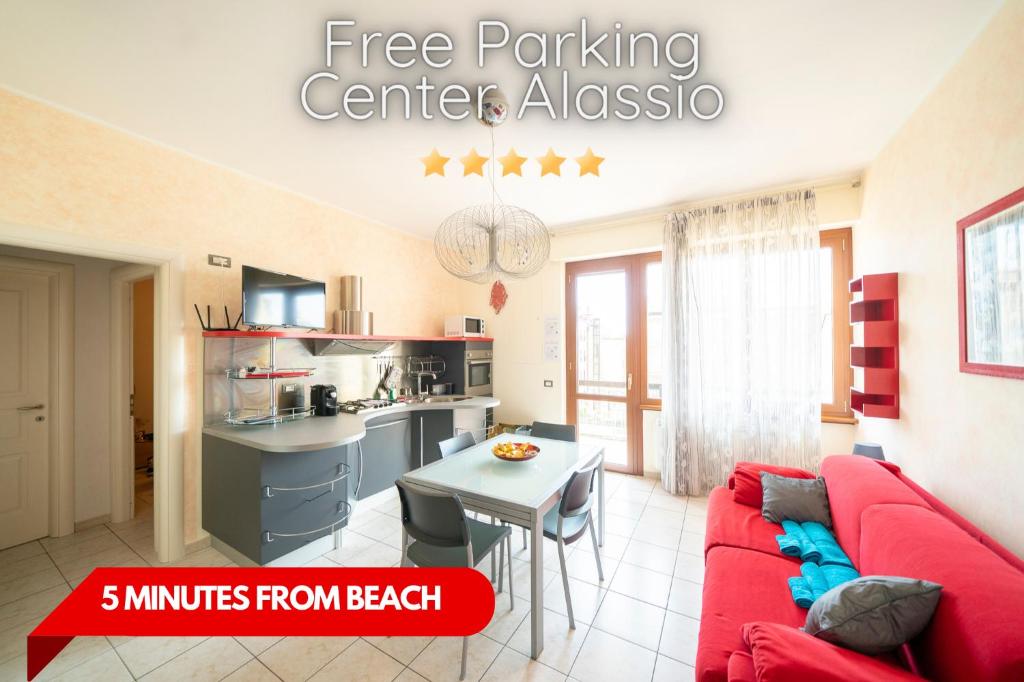 uma sala de estar com um sofá vermelho e uma cozinha em Free Parking 5 min dal Mare ad Alassio Centro em Alassio