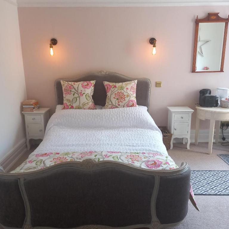 a bedroom with a large bed with pink walls at Beautiful self-contained annex/Cottage in Hoylake