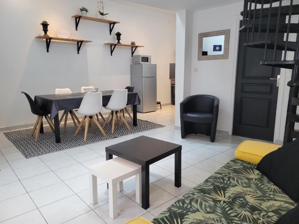 a living room with a table and chairs and a couch at Loft 4 du Temple HyperCentre & Parking in Cambrai