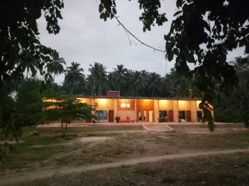 Taman Baloho Indah - Hotel & Resort في Telukdalem: وجود رجل امام المنزل ليلا