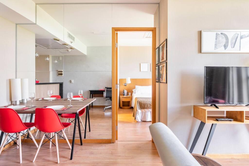 a dining room with a table and red chairs at Flat completo e charmoso Brasil 21 Suítes in Brasilia