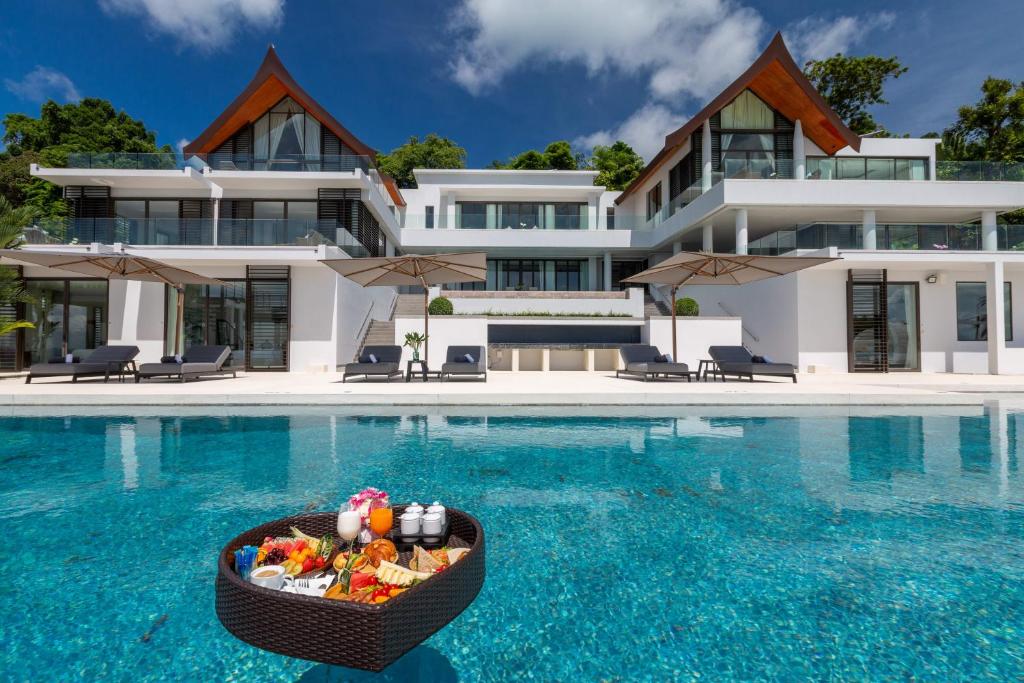 een zwembad van het resort met een kom eten in het water bij Villa Arun in Phuket