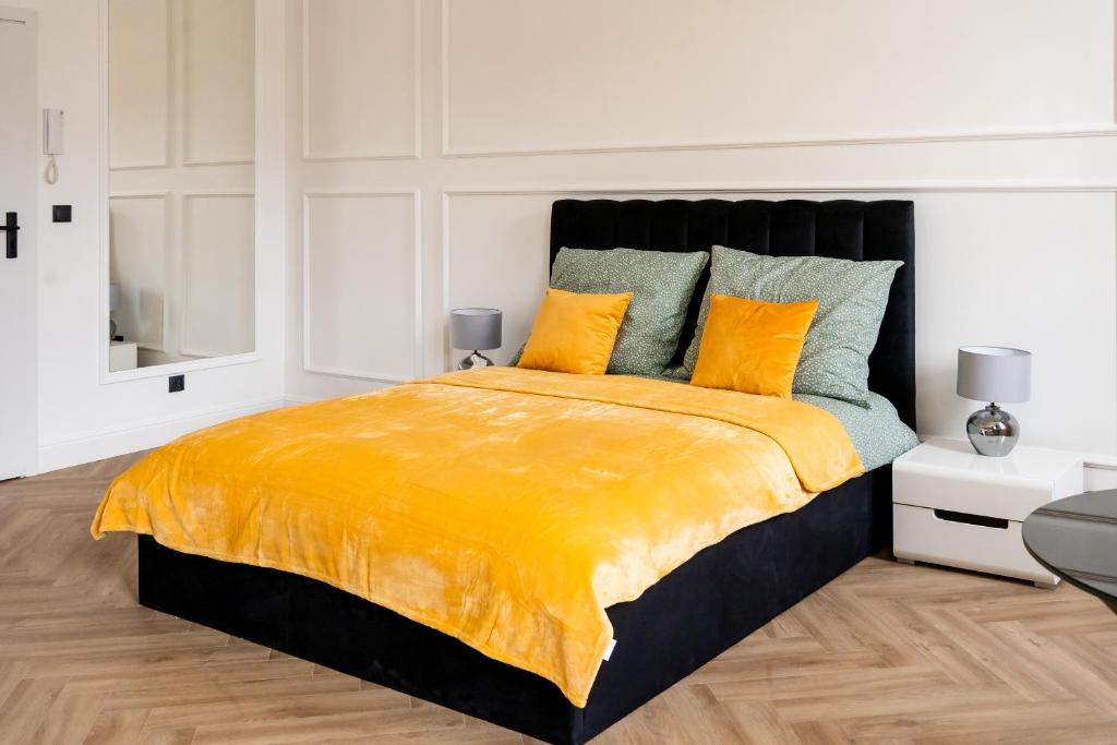 een slaapkamer met een groot bed met gele lakens bij SKYAPART in Kłodzko