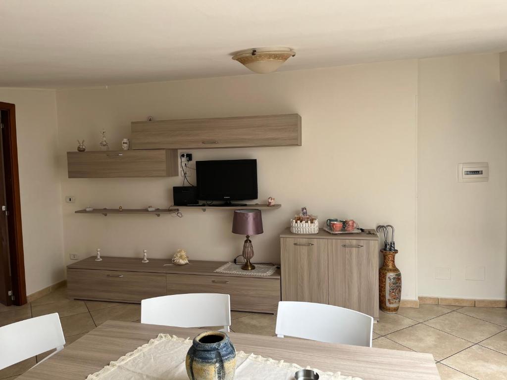 een woonkamer met een tafel en stoelen en een televisie bij Casa vacanze SOLAR in Poggiomarino