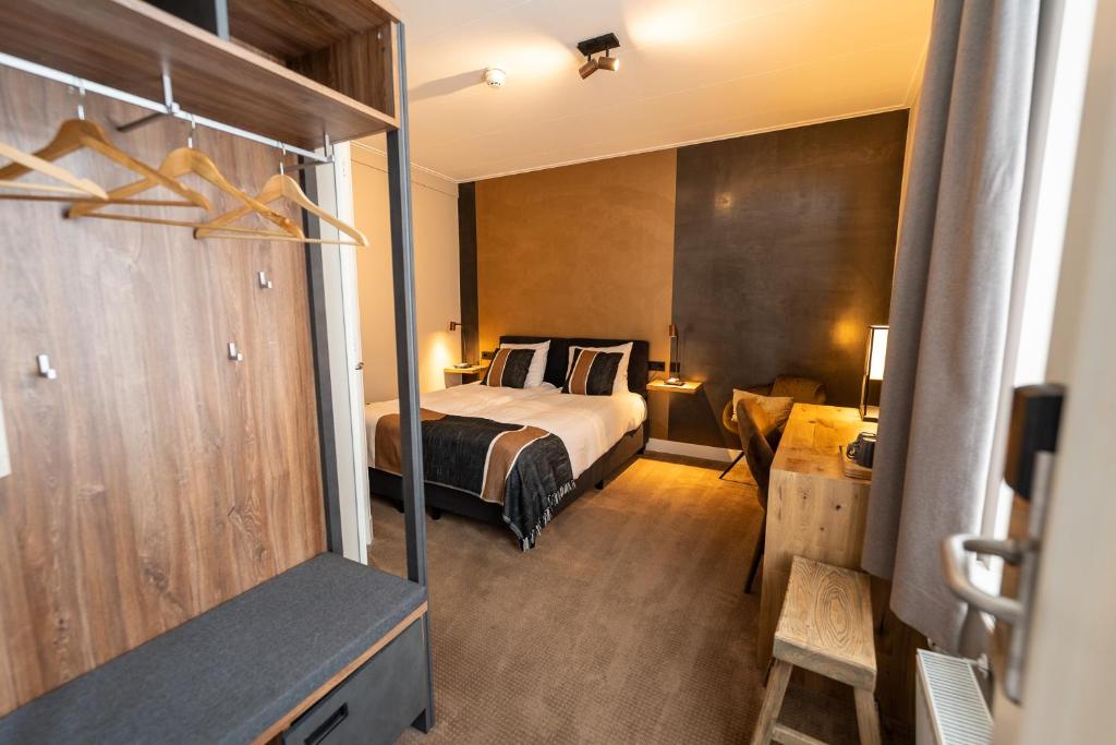 een hotelkamer met een bed, een bureau en een televisie bij Hotel Montfoort in Montfoort