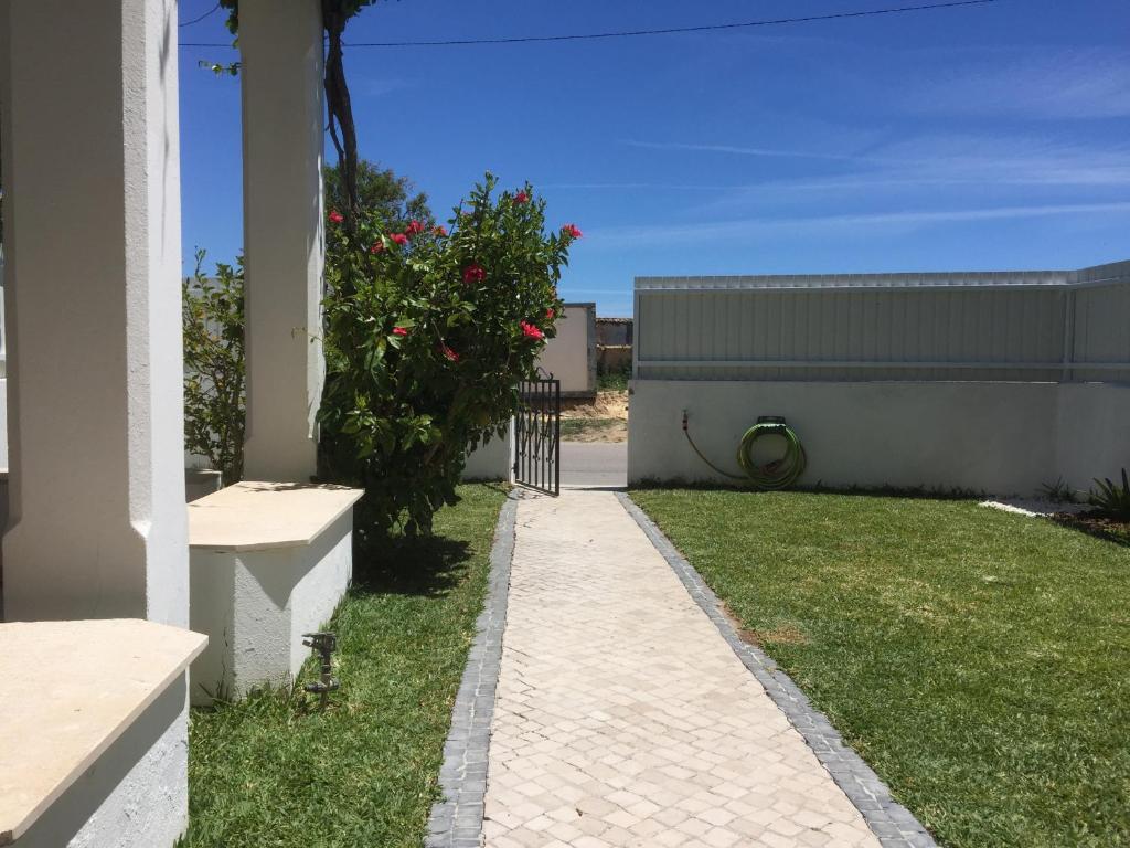 un passaggio pedonale accanto a una casa con un cespuglio di Apartamento perto da Praia Coelha ad Albufeira