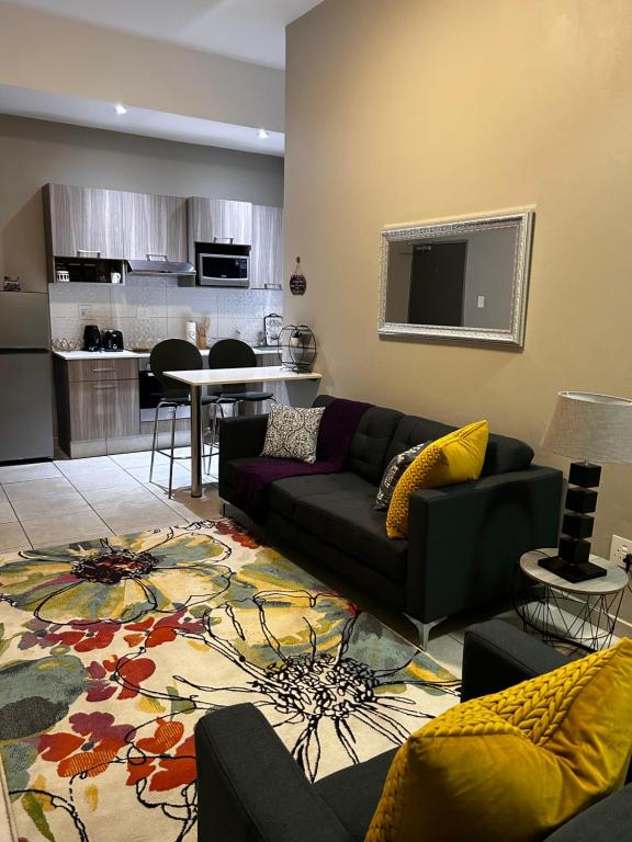 een woonkamer met een bank en een tafel bij Neat and cozy apartment in central Rosebank with unlimited Wi-Fi and backup power in Johannesburg