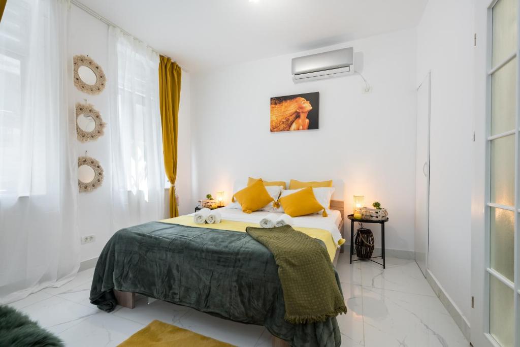 ein weißes Schlafzimmer mit einem Bett mit gelben Kissen in der Unterkunft Light-Monza-Unirii in Bukarest