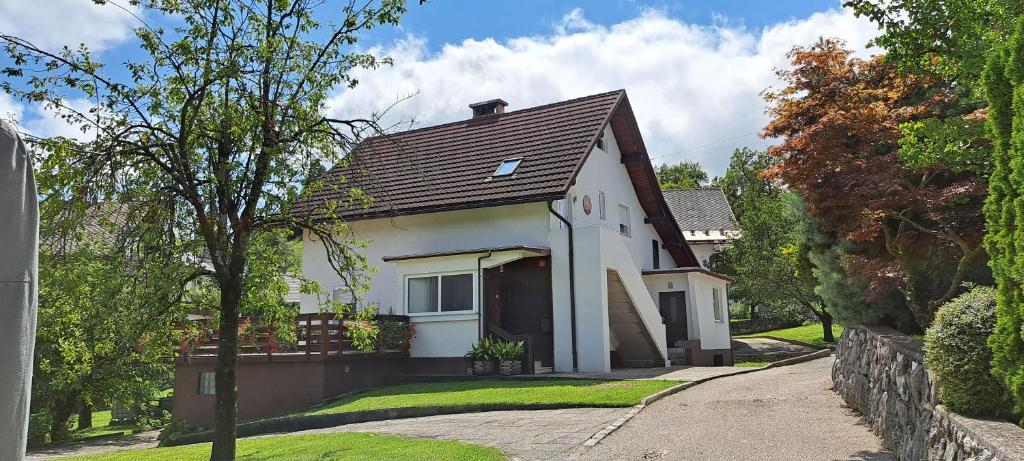 ein weißes Haus mit braunem Dach in der Unterkunft Apartma Bine in Bled