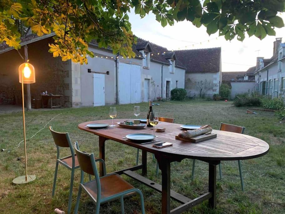 - une table en bois avec des chaises et une bouteille de vin dans l'établissement Maison de famille - grand jardin clos - 15mn du zoo de Beauval, à Selles-sur-Cher