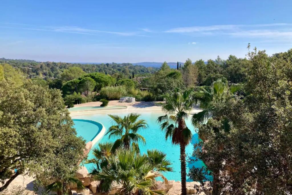 une vue aérienne d'une piscine avec des palmiers dans l'établissement Bright cocoon with garden and sea view, à Grimaud