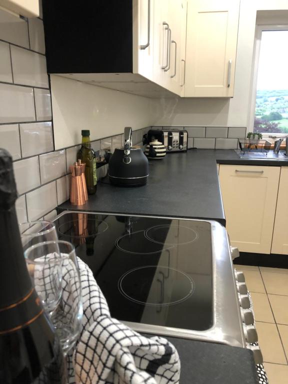 a kitchen with a sink and a stove top oven at Hilltop House is a welcoming 2 bedroom property in Matlock