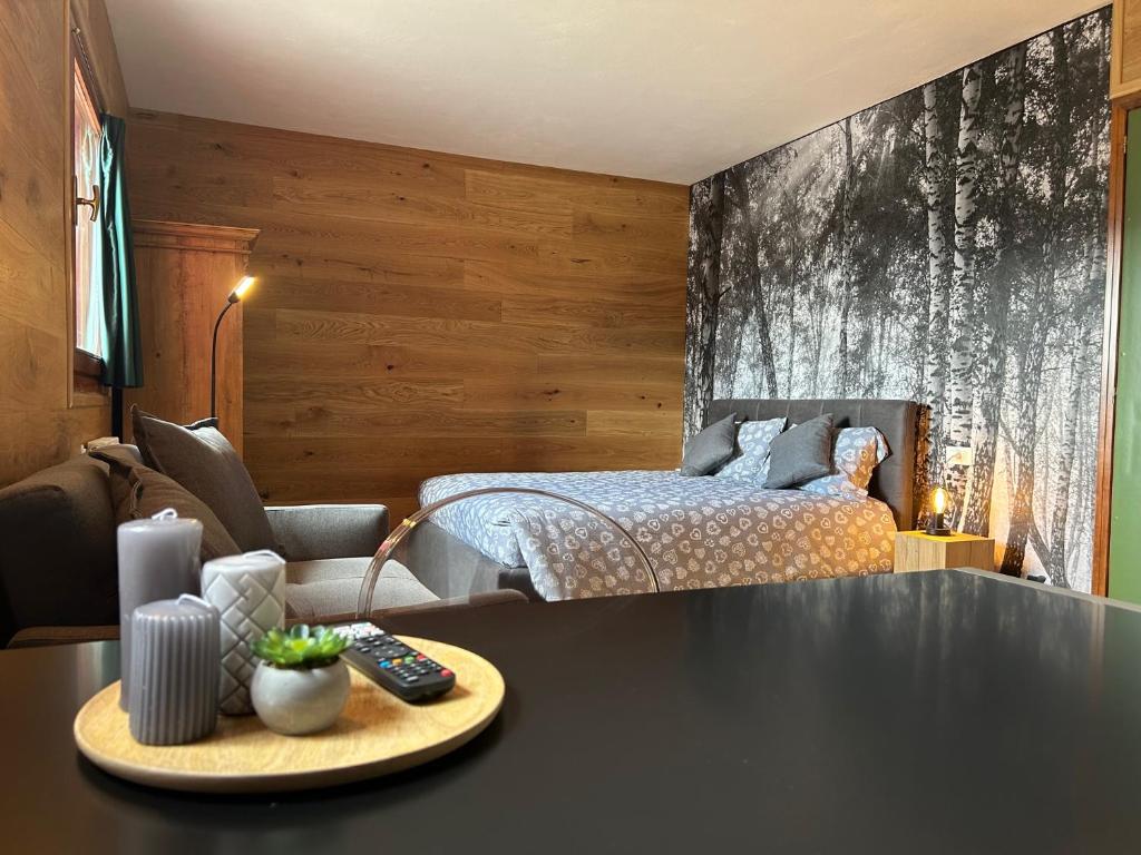 a bedroom with a bed and a table in front of it at Perla Dolomiti Falt in Falcade