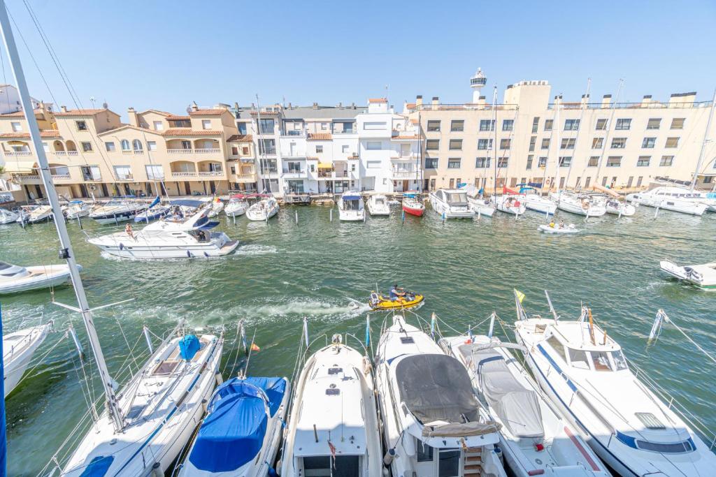 un groupe de bateaux amarrés dans un port avec des bâtiments dans l'établissement ref 403, à Empuriabrava