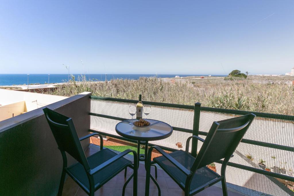 Ein Tisch und Stühle auf einem Balkon mit Meerblick in der Unterkunft Seaside Deluxe Flat in Peniche
