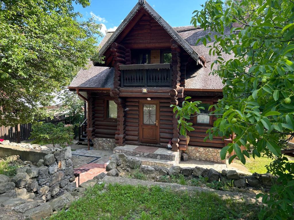 a log cabin with a porch and a door at Cabana Haiducului in Soveja