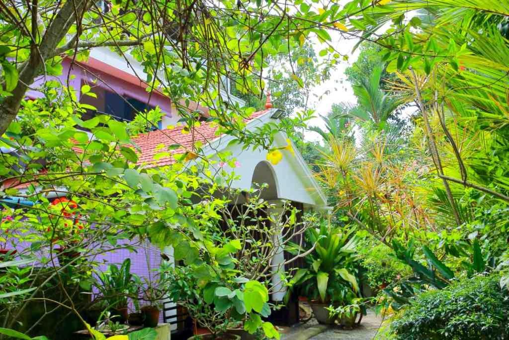 a bird house in the middle of a garden at Bella Homestay Kerala in Alleppey