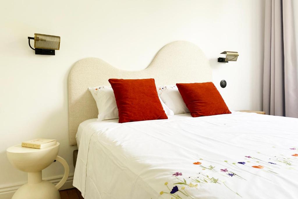 グルノーブルにあるLe petit Versailles - T2 au centre-villeのベッドルーム(白いベッド、赤い枕付)