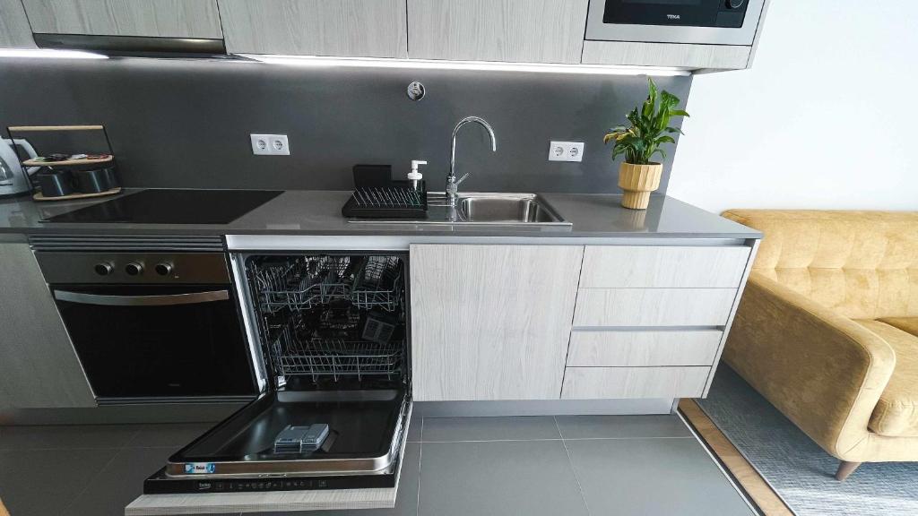 a kitchen with a sink and a stove top oven at Apolo71 Alojamentos in Bragança