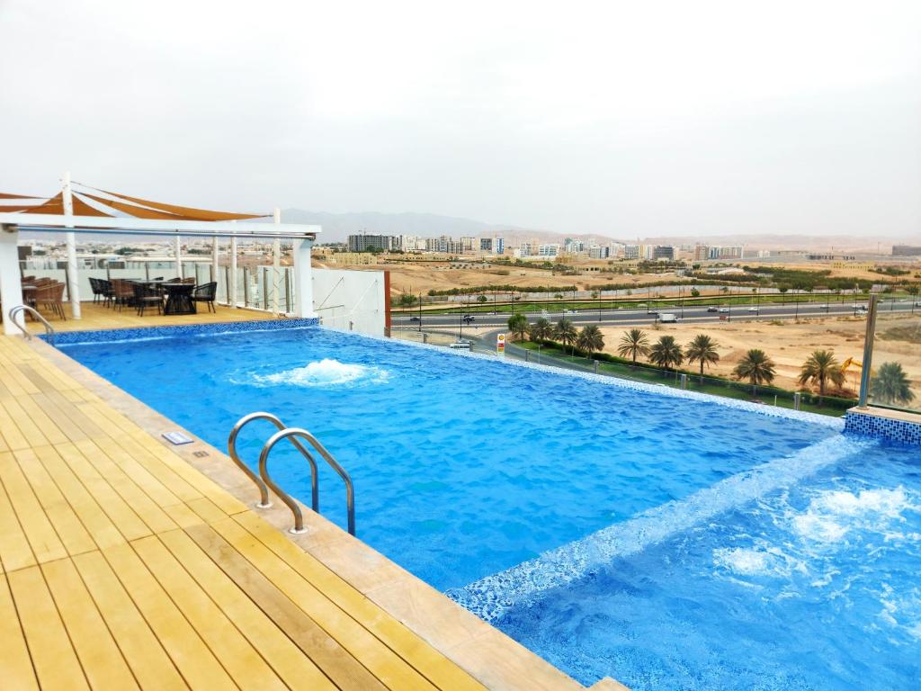 a large blue swimming pool on top of a building at Carnelian by Glory Bower Hotels in Muscat