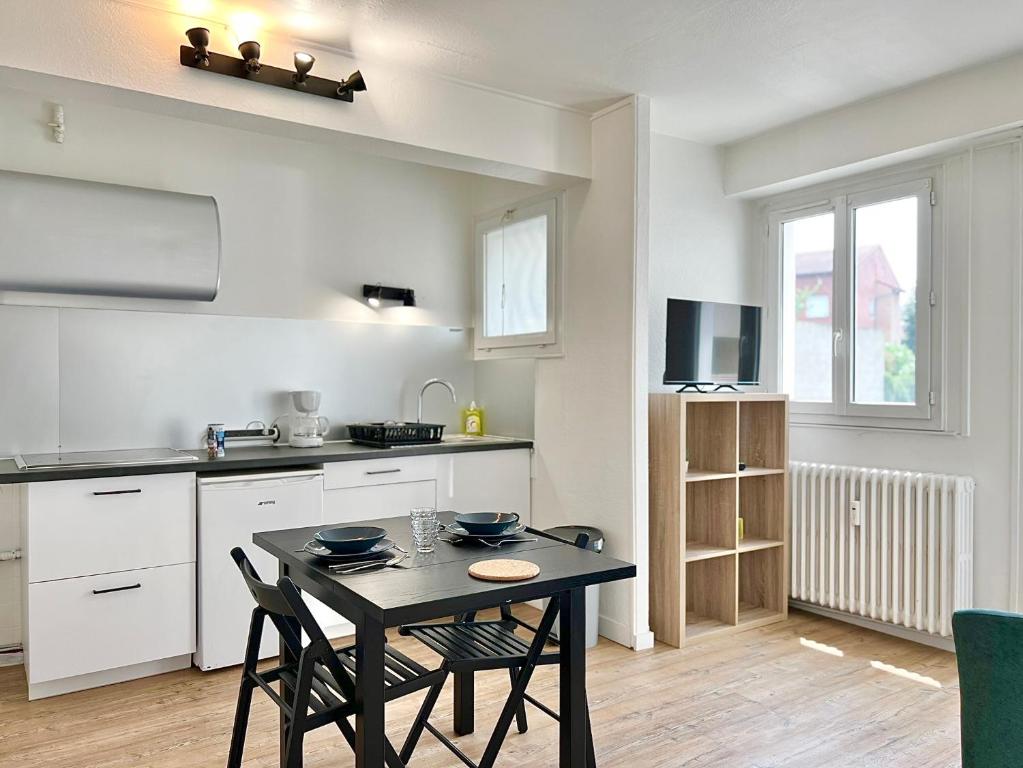 une cuisine avec une table et des chaises dans une pièce dans l'établissement Le Saint Agne, à Toulouse