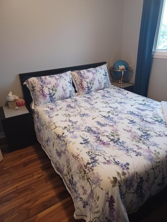 a bedroom with a bed with a floral comforter at Ajax Holiday in Ajax
