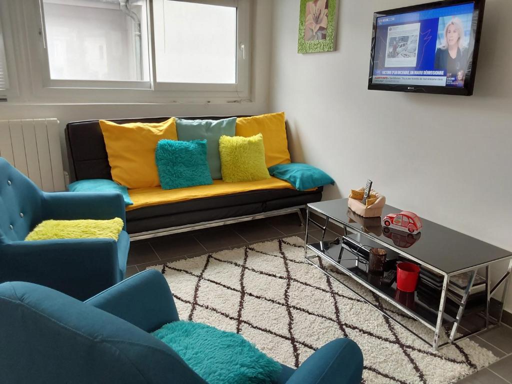 - un salon avec un canapé et des oreillers colorés dans l'établissement Appartement douillet eaux bonnes/vallée d’ossau, à Eaux-Bonnes