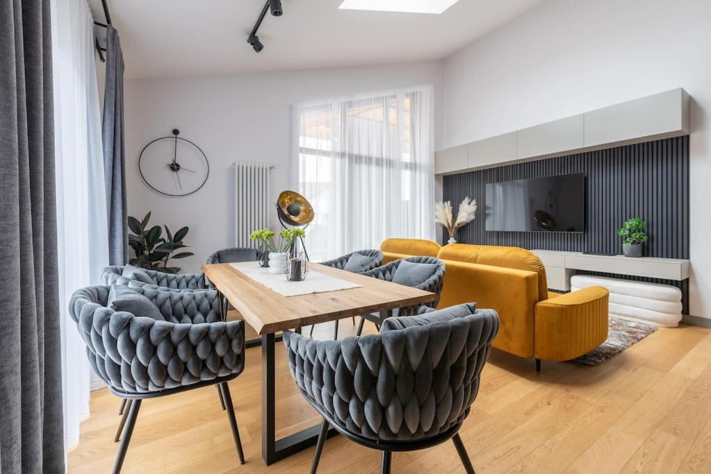uma sala de estar com mesa e cadeiras em Luxurious penthouse with parking em Riga