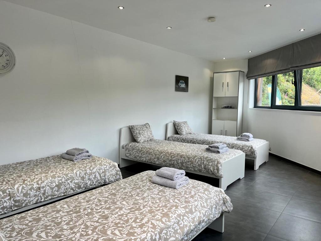 three beds and a couch in a room at Loft à la Source in Francorchamps