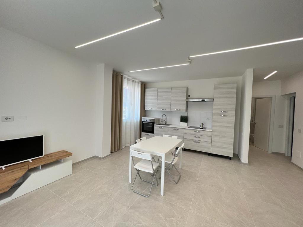 um quarto branco com uma mesa e uma cozinha em Villa Family House , Senigallia , Trecastelli (AN) em Molino di Ripe
