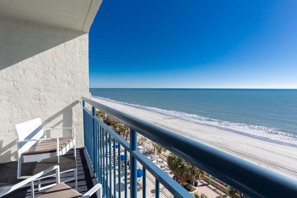 a view of the beach from the balcony of a beach house at Modern 1BR Oceanfront Condo at Coral Beach Resort in Myrtle Beach