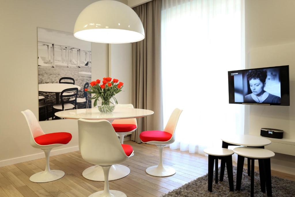 sala de estar con mesa, sillas y TV en Apartament Soleil I, en Gdansk