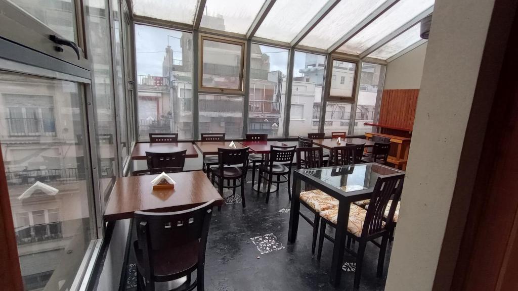 un restaurante con mesas y sillas y una gran ventana en Hostel Che Boutique en Buenos Aires