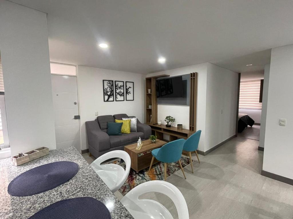 sala de estar con sofá, mesa y sillas en Magnifico y confortable apartamento amoblado # 303 en Bogotá