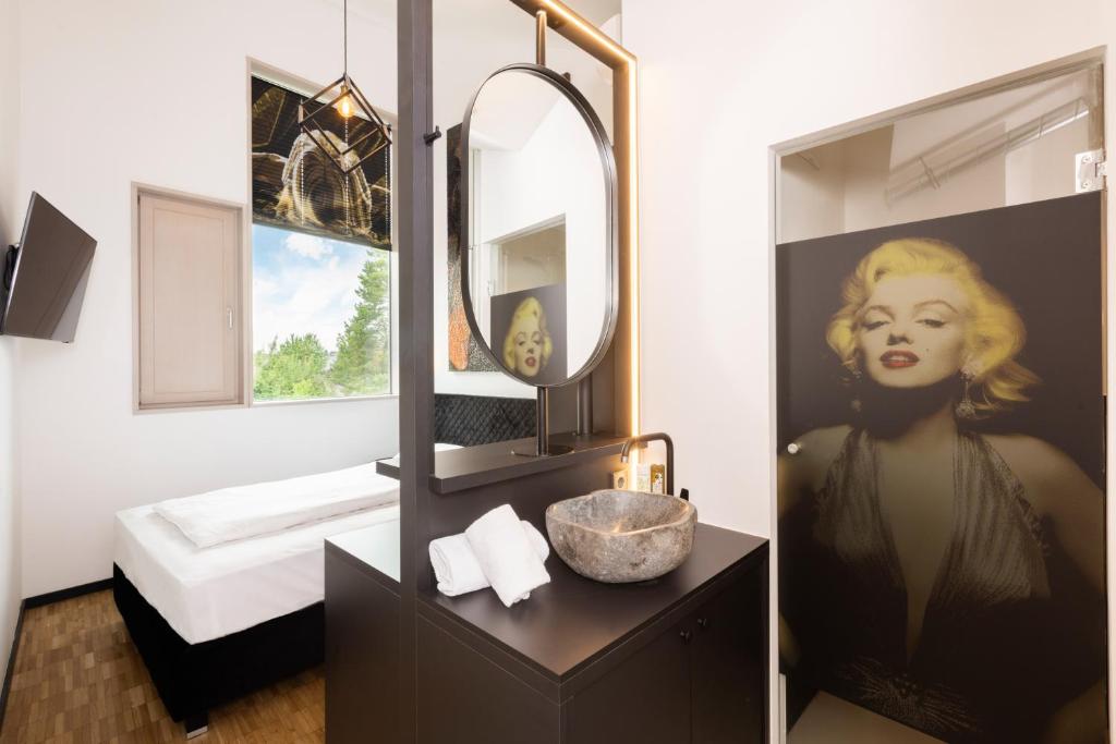 a bathroom with a large mirror and a sink and a vanity with a sink at Das Edlinger in Salzburg