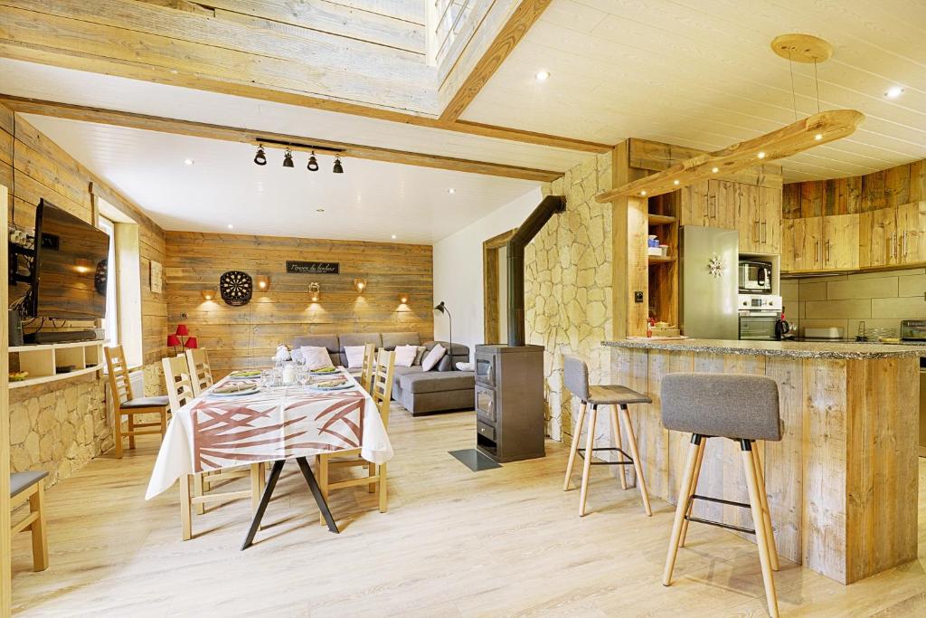 a dining room and kitchen with a table and chairs at Le Ptit Bonheur - avec vue montagne et terrasse in La Bresse