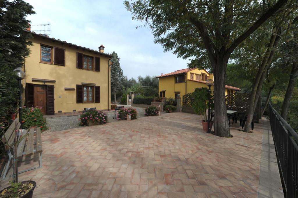 une maison avec un arbre et une allée en briques dans l'établissement Gli Oleandri, à Castelfiorentino