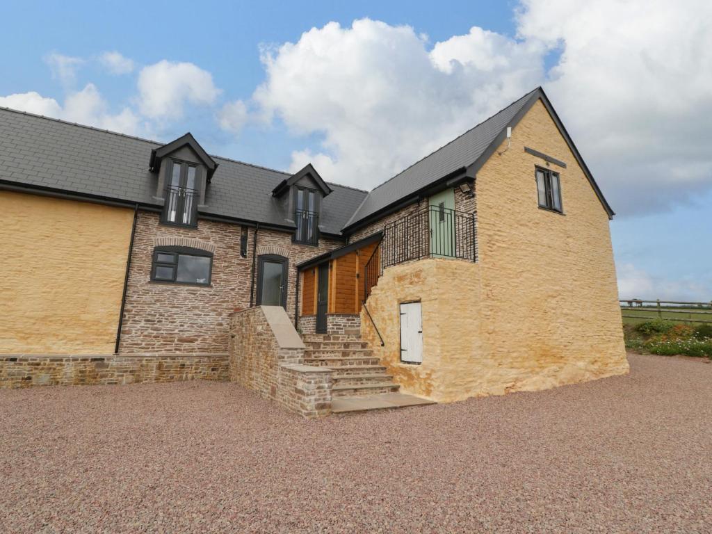 a large brick house with stairs in front of it at Palace Farmhouse in Hereford