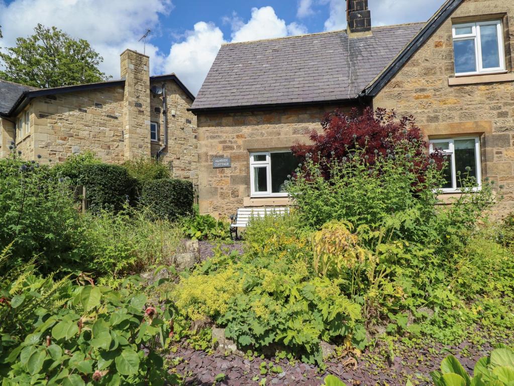 a stone house with a garden in front of it at Alnside Cottage in Alnmouth