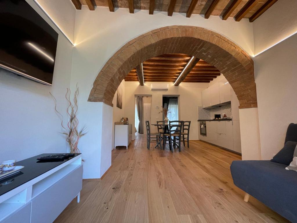 an open kitchen and living room with an archway at CASA DI ELENA in Montalcino