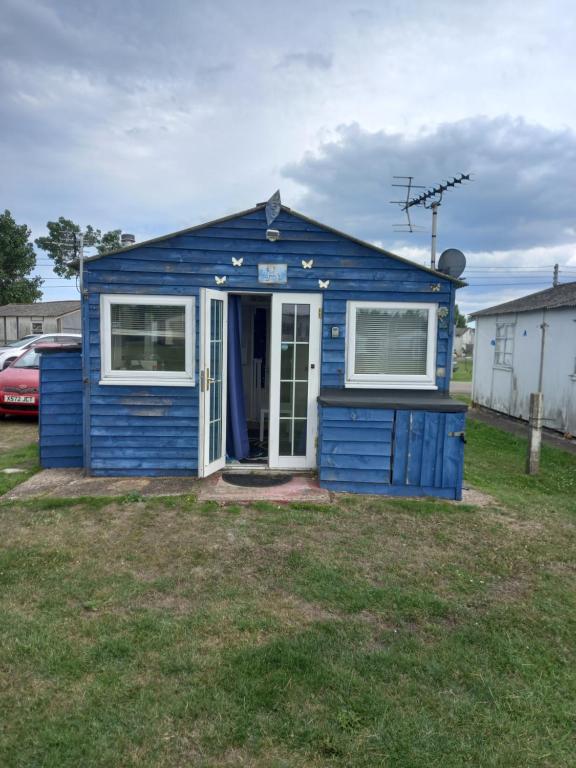 una casita azul sentada en un patio en Bluebell chalet en Leysdown-on-Sea