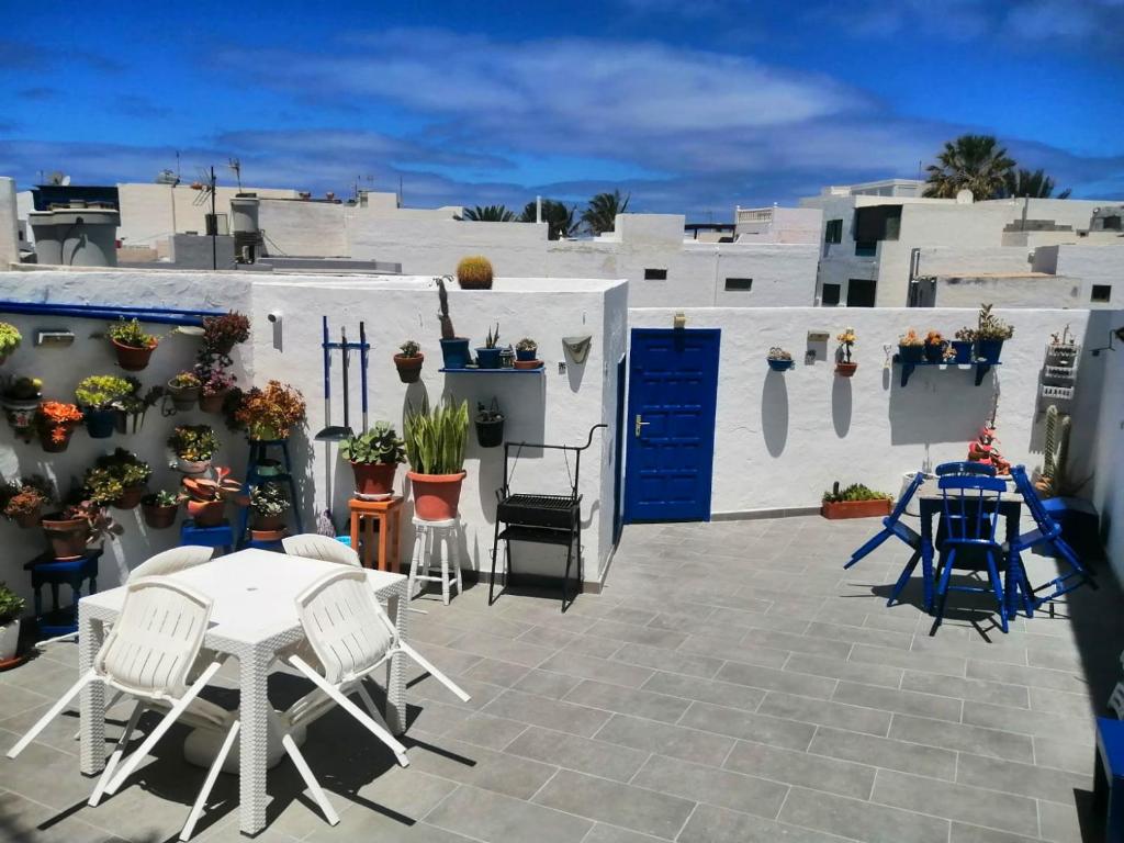 a patio with a table and chairs and white buildings at 3 bedrooms house at El Golfo Lanzarote 500 m away from the beach with furnished terrace and wifi in El Golfo