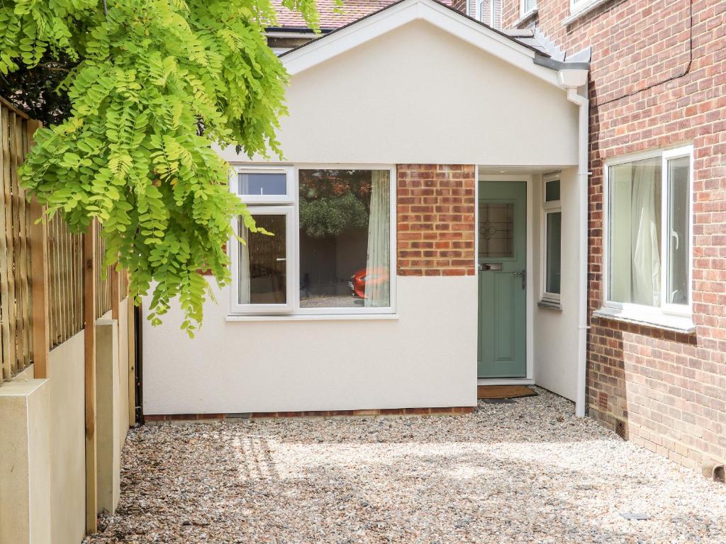 a house with a green door and a brick building at The Garden House Cottage in Whitstable