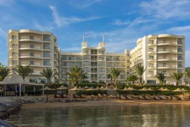 a large building with a resort and a body of water at Royal Star Beach Resort in Hurghada