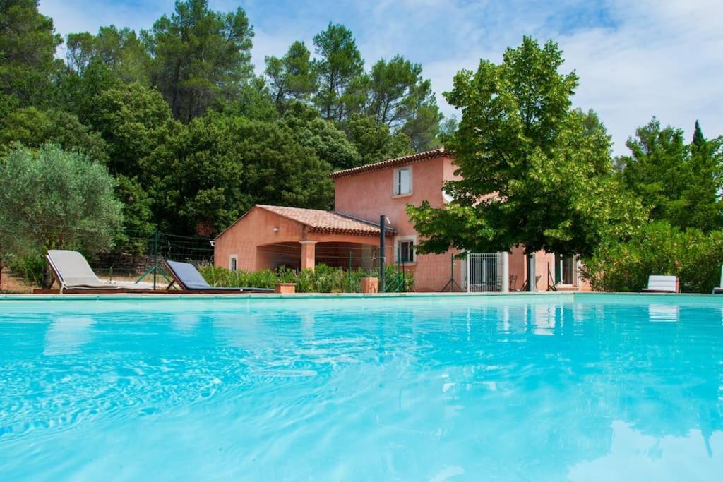 una gran piscina frente a una casa en Le mas dans les Oliviers, en Flassans-sur-Issole